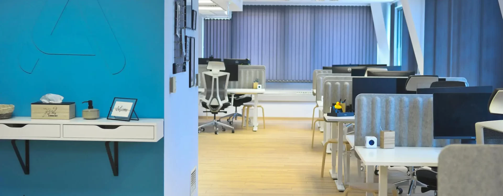 A photograph of Parachut's office with a 3D logo on a wall and working office desks.