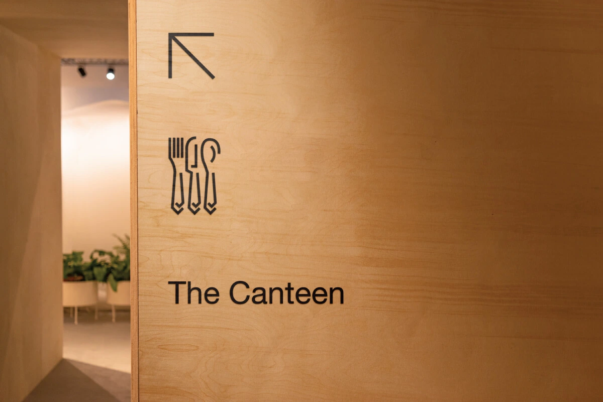 Canteen sign engraved in wooden wall, part of an office visual communication.