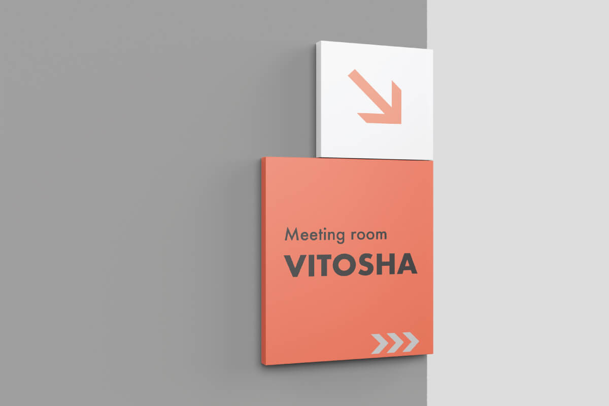 Indoor wall-mounted directional sign, part of an office visual communication.