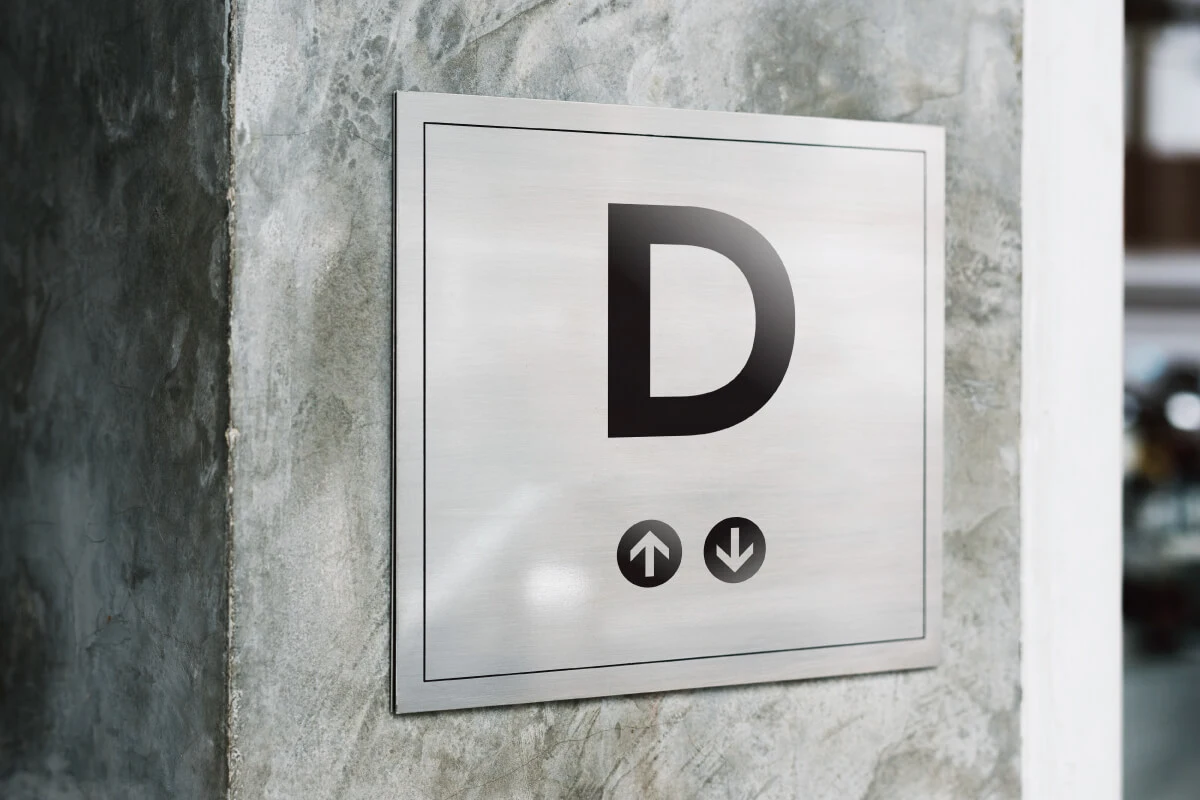Elevator wall-mounted directional sign, part of an office visual communication.