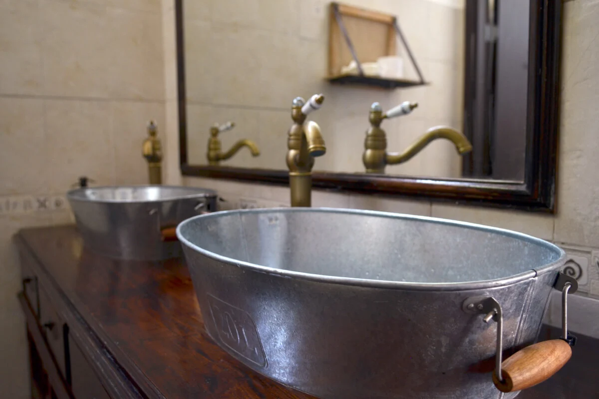 A photograph of The old man and the sea restaurant's custom-made restroom vintage sinks and mirror.