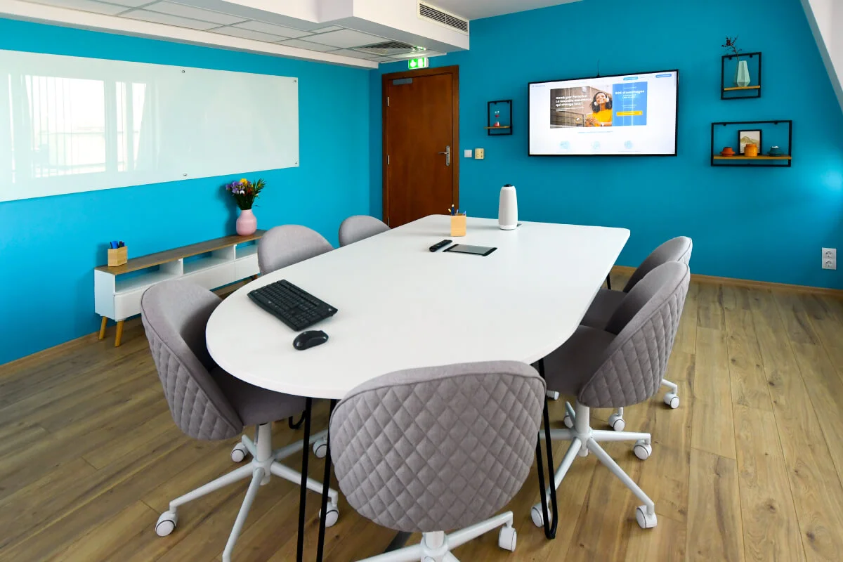 A photograph of Parachut's office meeting room with custom branded whiteboards, a half-round meeting table, and soft chairs on wheels.
