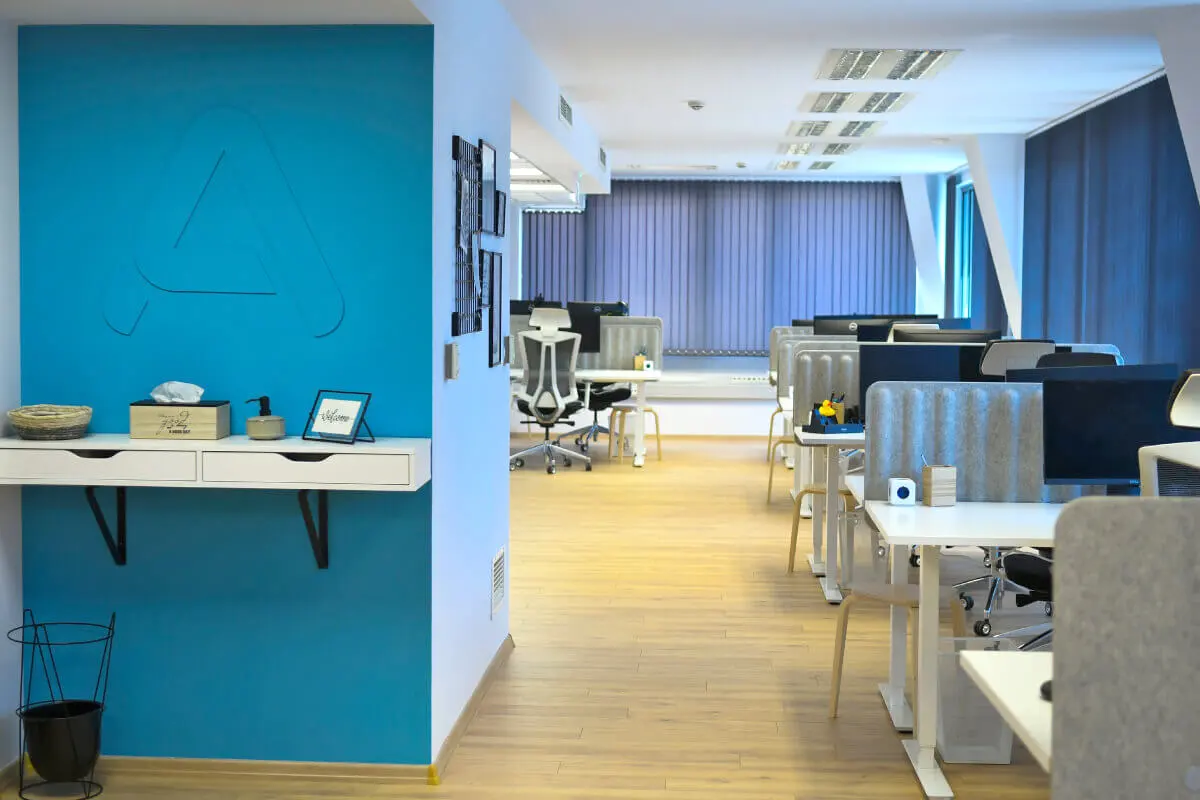 A photograph of Parachut's office with a 3D logo on a wall and working office desks.